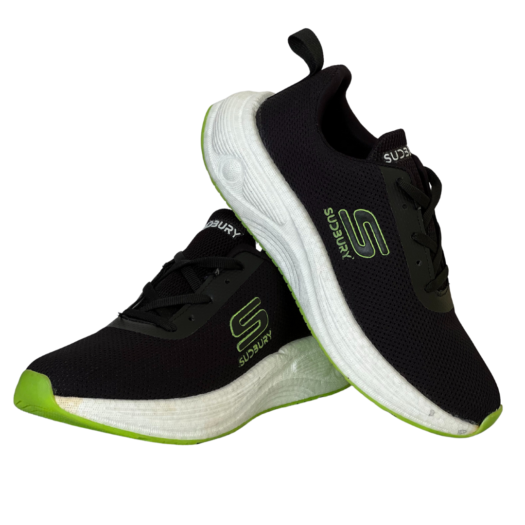 Black and green running shoes with white soles on a white background